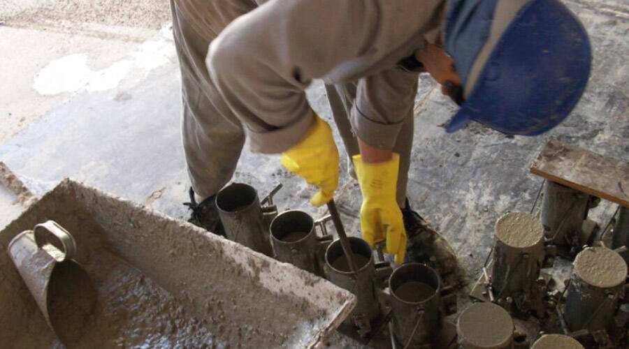Pedreiro realizando ensaio de resistência a comprensão.