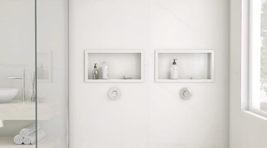 Nicho de banheiro de porcelanato com shampoo e saboneteira.